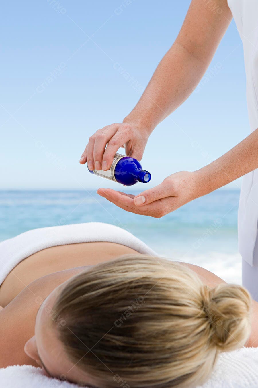 Massagem relaxante na praia com óleo azul