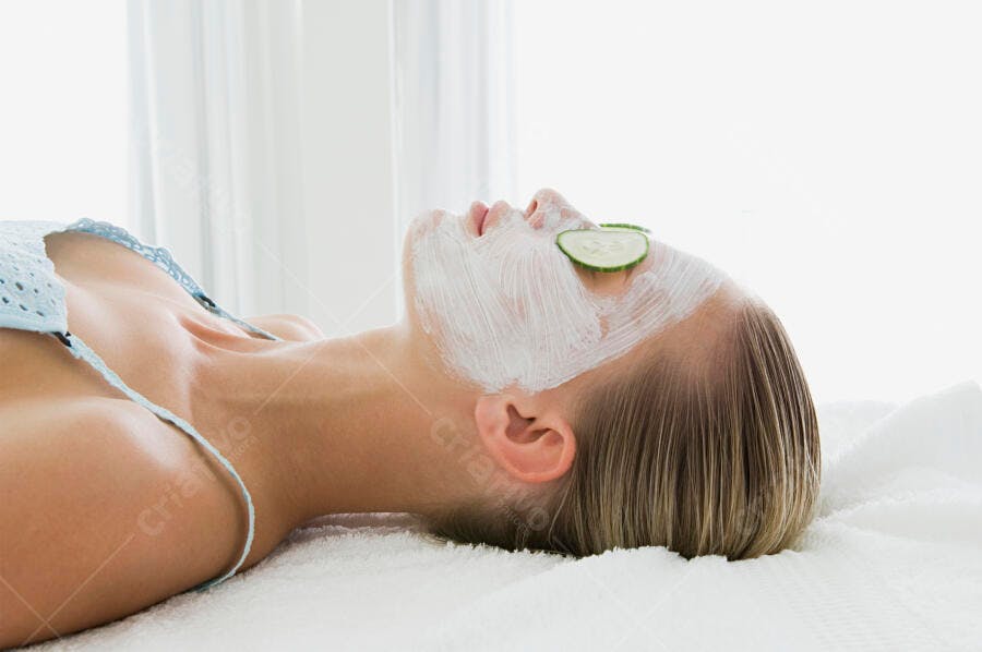 Mulher recebendo tratamento facial com máscara e pepino