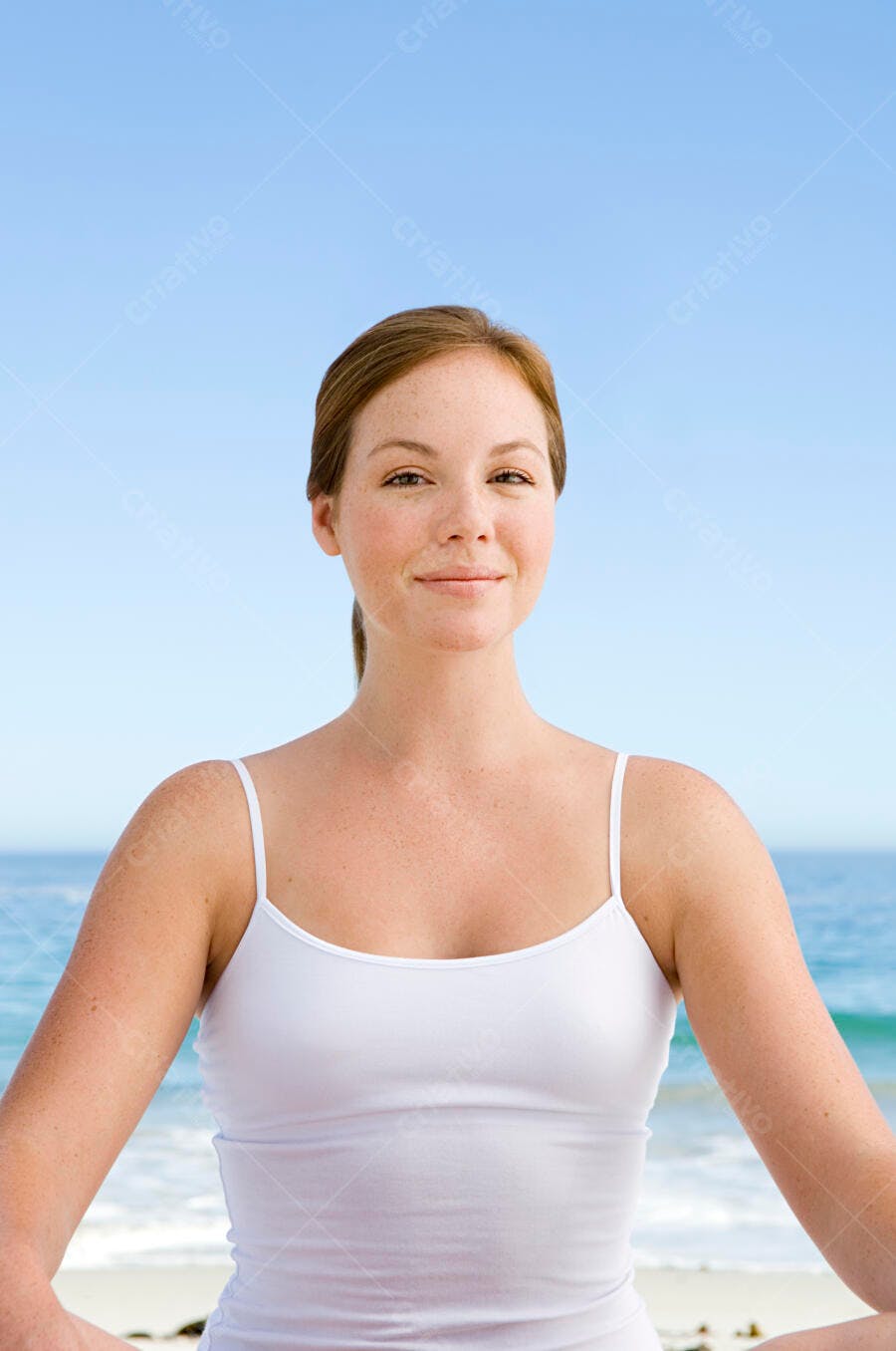 Mulher meditando na praia sorrindo