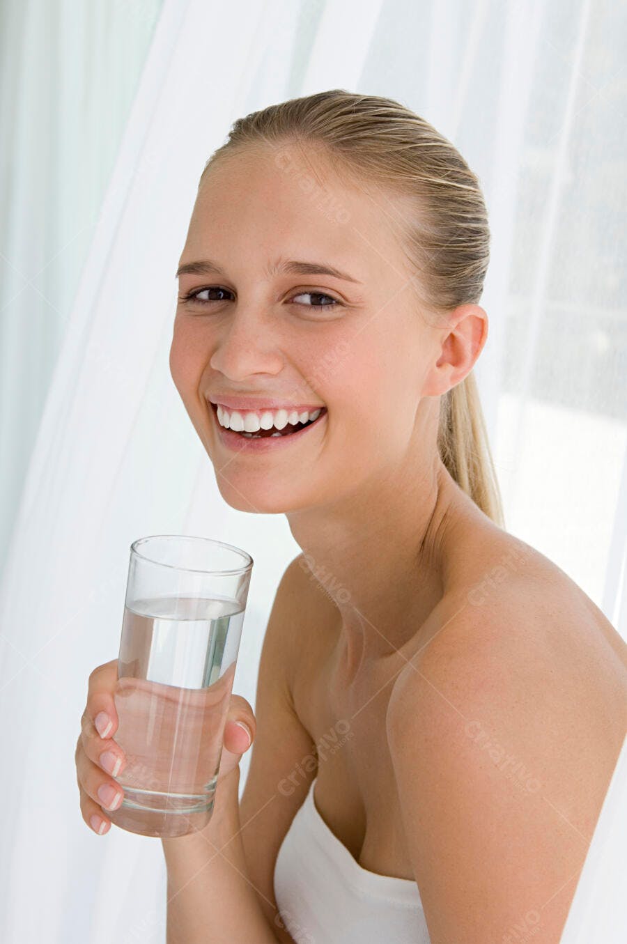 Mulher sorrindo segurando copo d'água