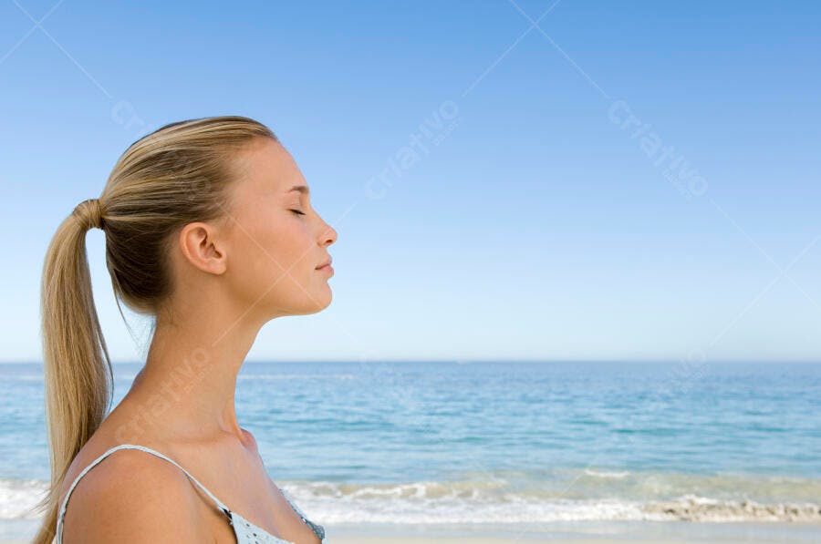 Mulher loira na praia olhos fechados
