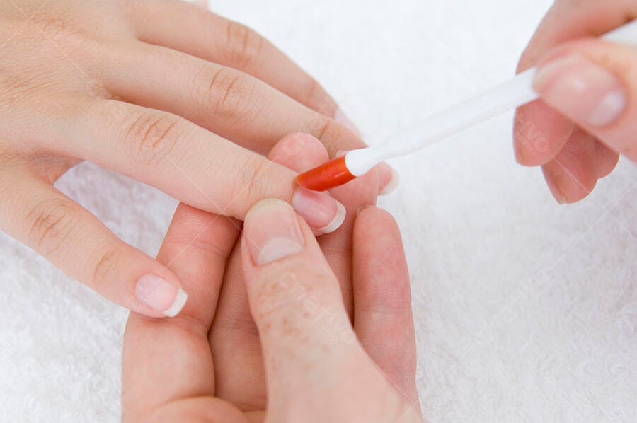 Manicure com esmalte vermelho aplicação de base