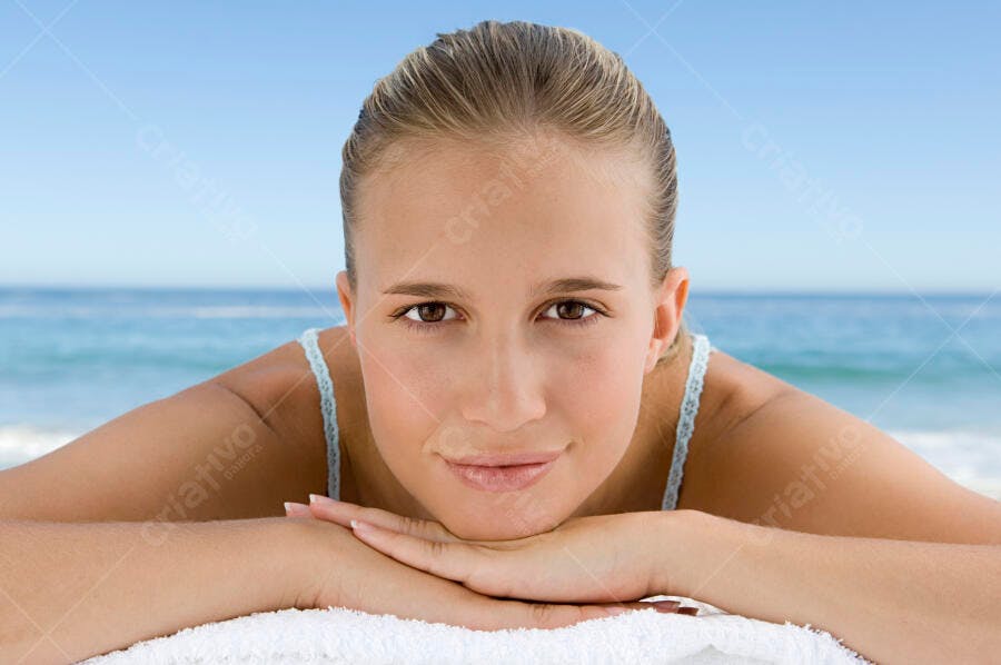 Mulher na praia relaxando na toalha