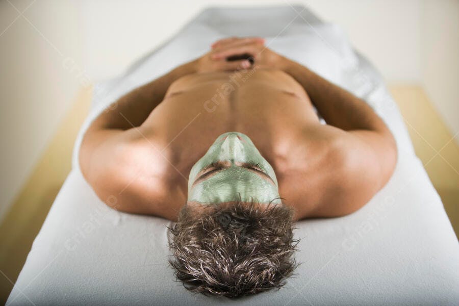 Homem com máscara facial verde em spa