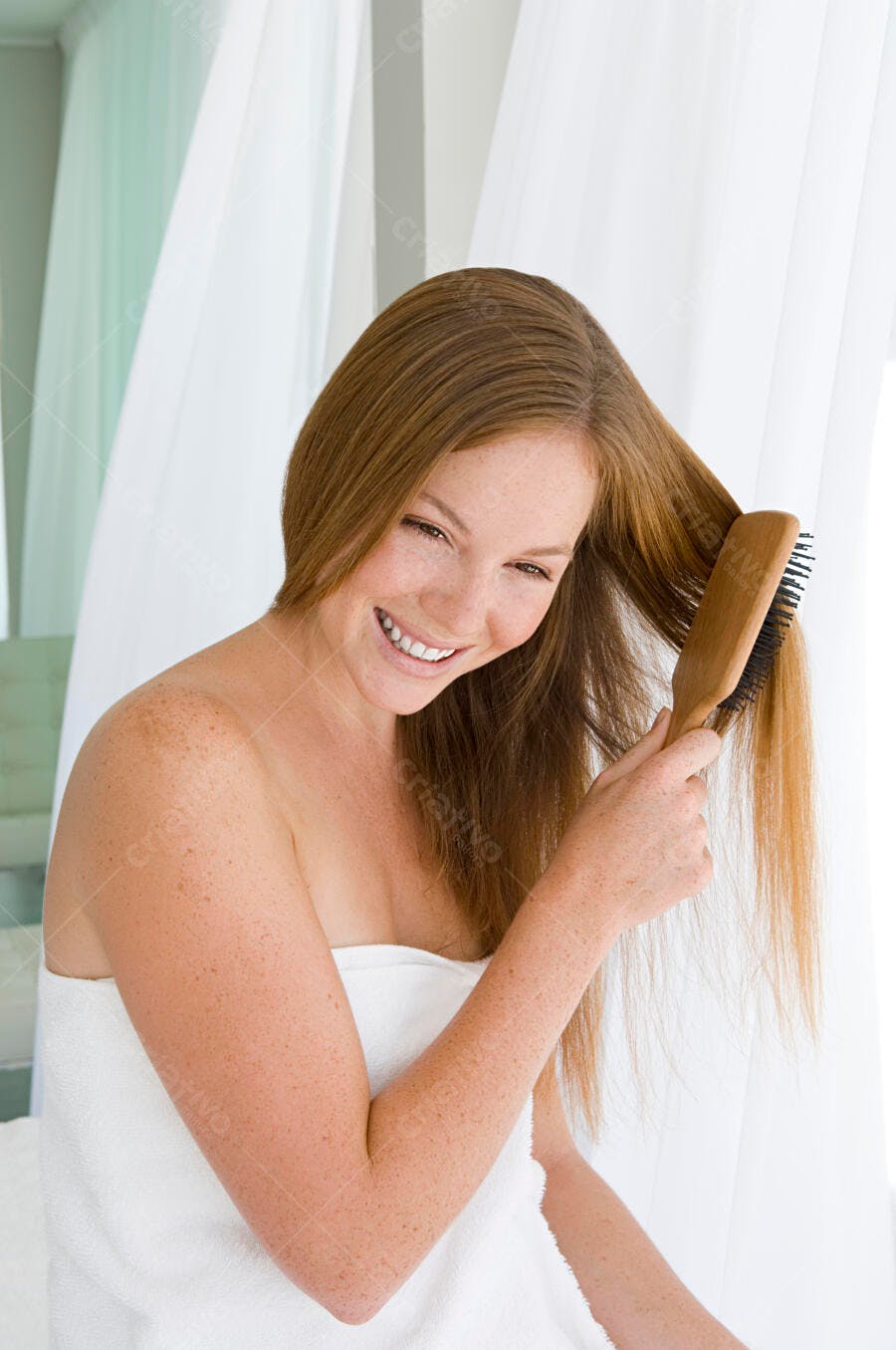 Mulher escovando cabelo longo castanho claro
