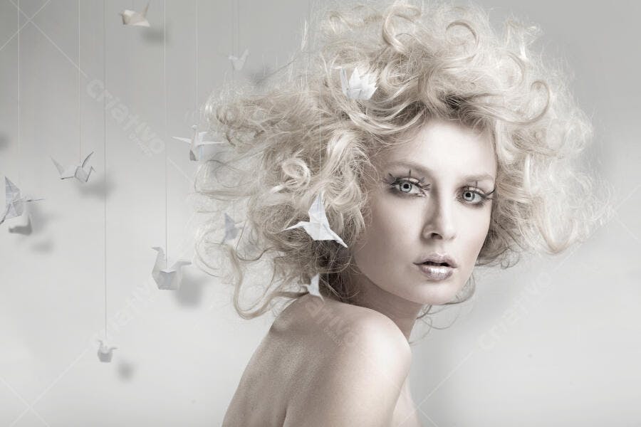 Modelo com cabelo loiro e pássaros de origami
