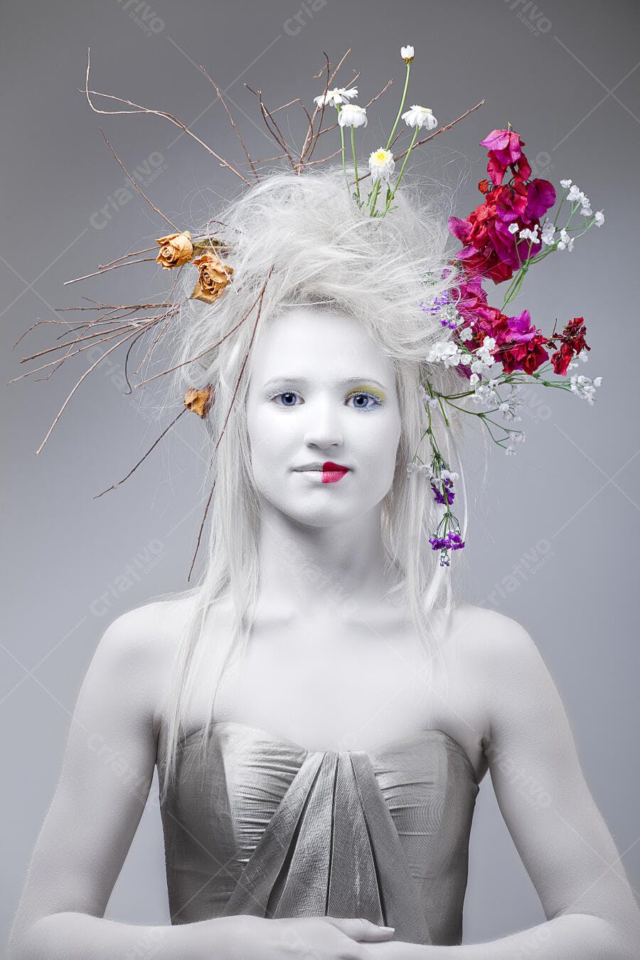 Modelo com flores no cabelo fundo cinza