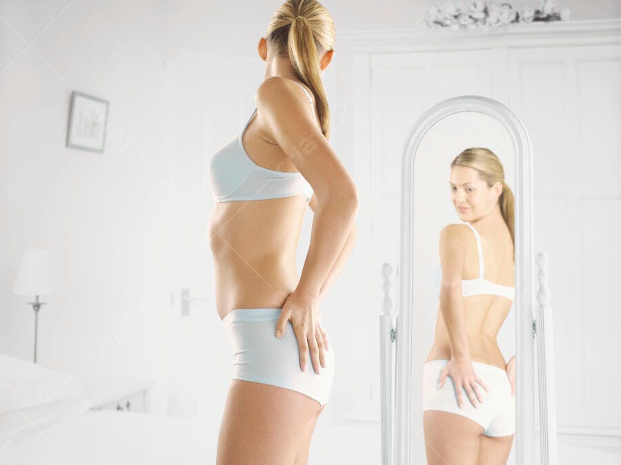 Mulher olhando-se no espelho em lingerie