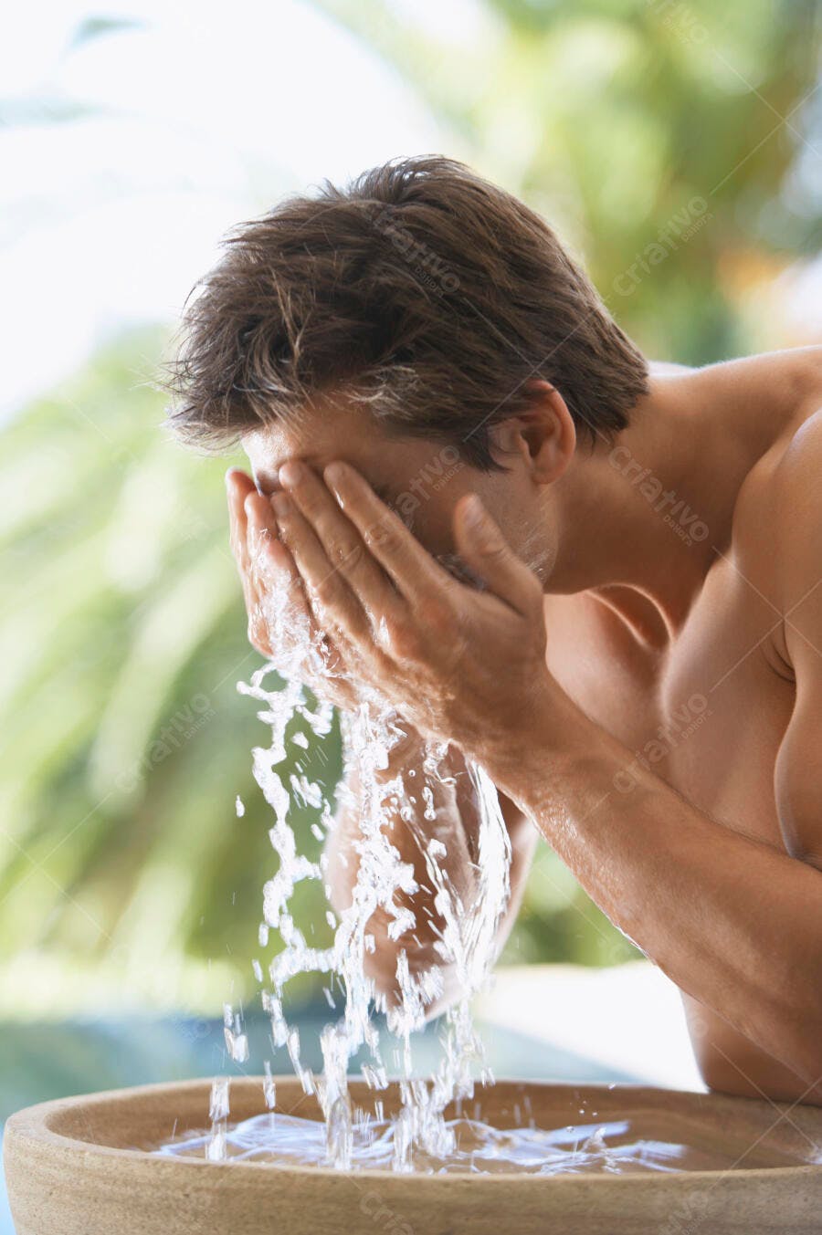 Homem lavando o rosto com água fresca ao ar livre