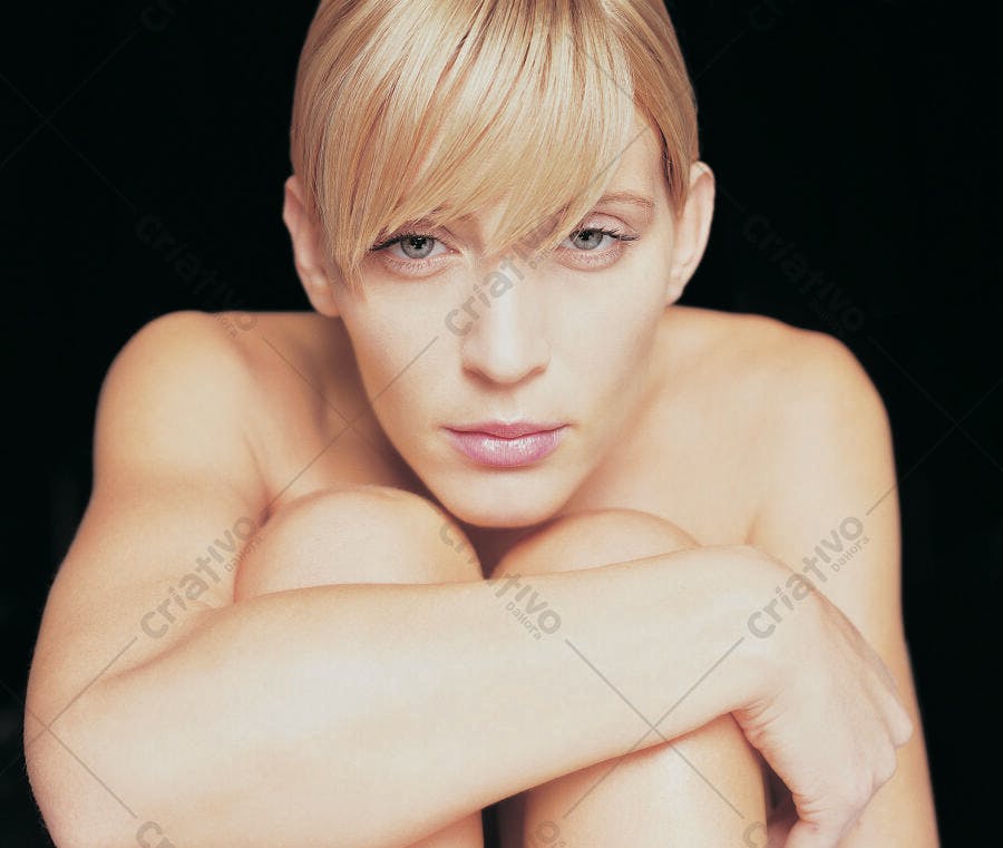 Mulher loira sentada com os braços nos joelhos