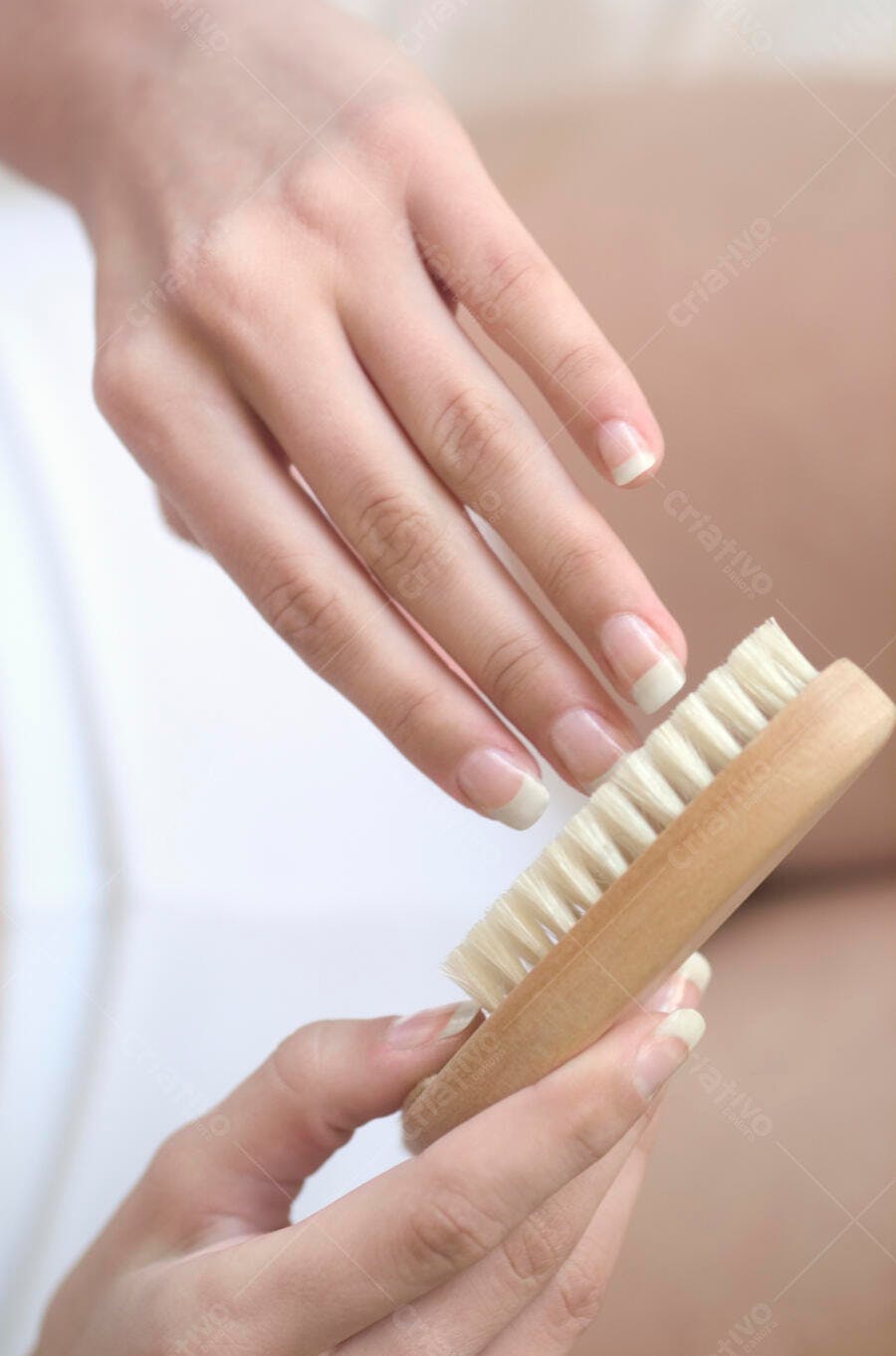 Mãos femininas segurando escova de unhas