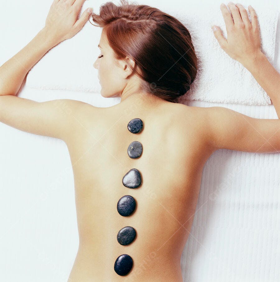 Mulher recebendo massagem com pedras quentes