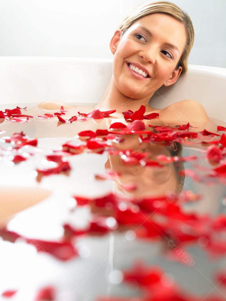 Mulher relaxando em banho de pétalas de rosas vermelhas