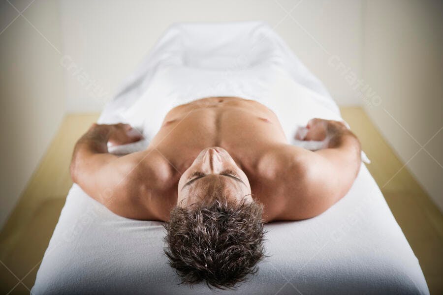Homem relaxado em mesa de massagem