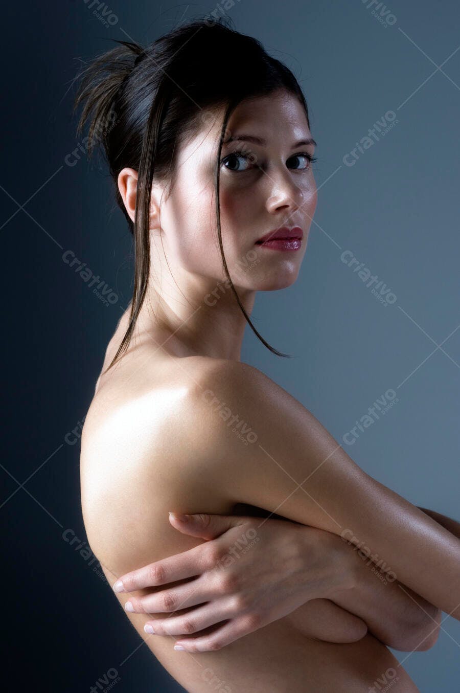 Mulher nua abraçando corpo fundo azul