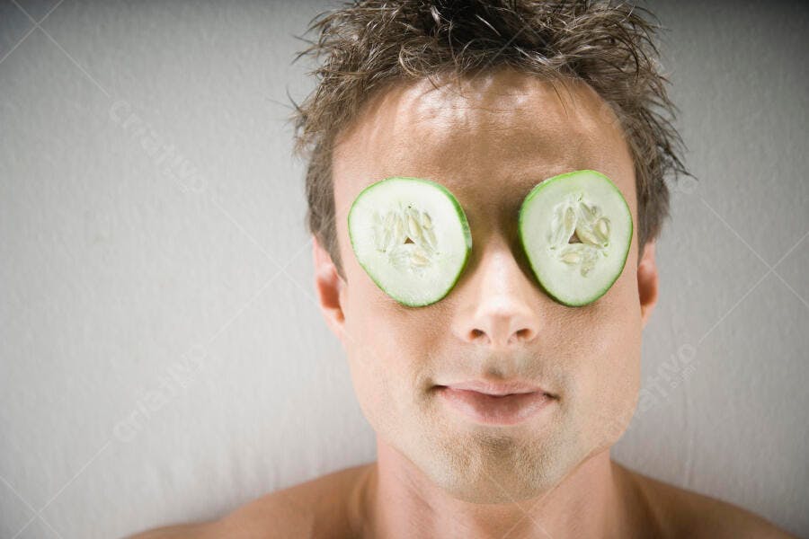 Homem com fatias de pepino nos olhos