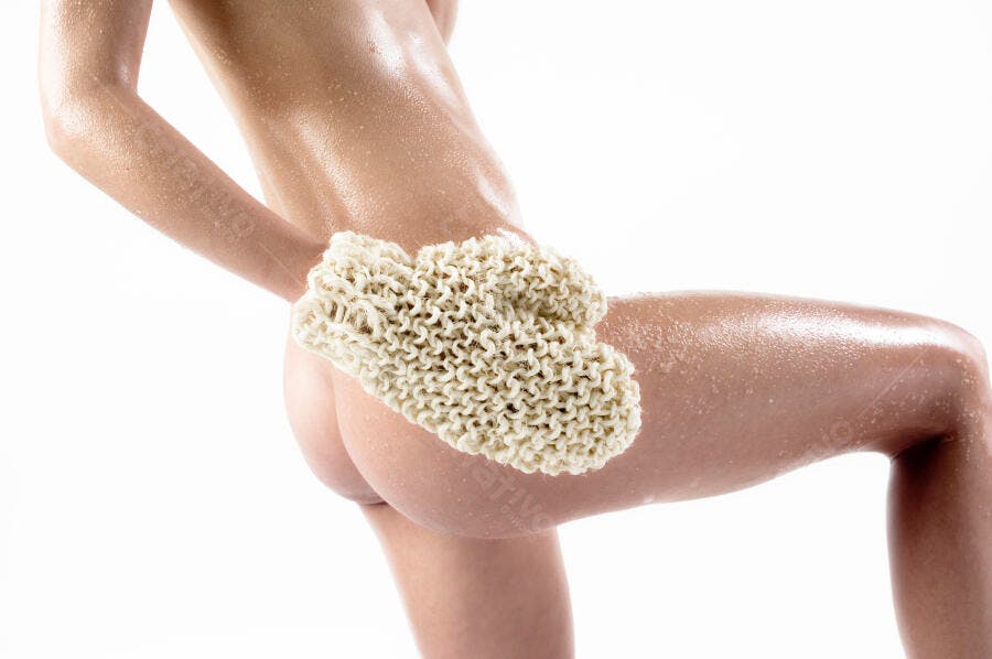 Mulher usando luva de banho de sisal