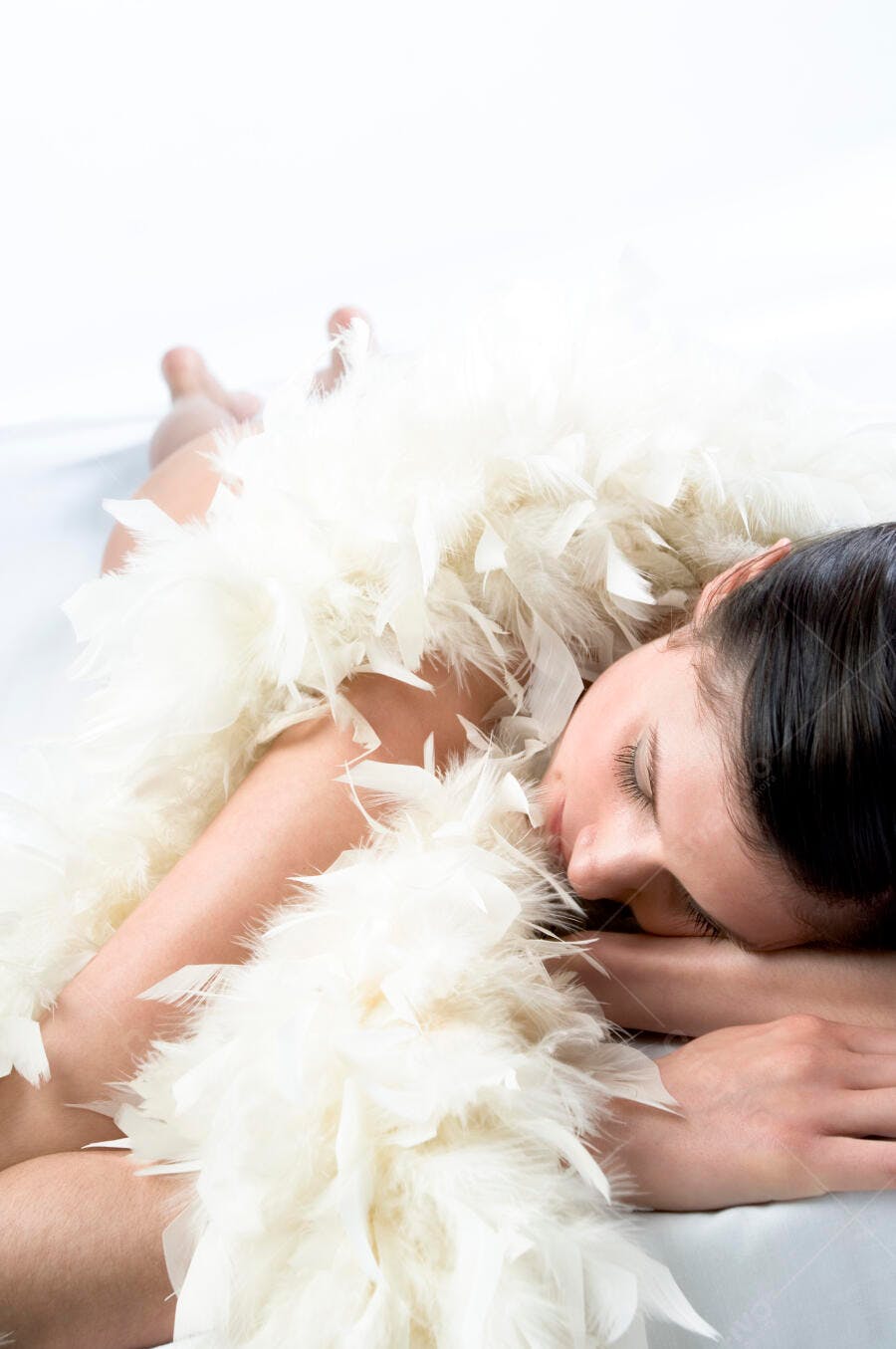 Mulher dormindo com plumas brancas
