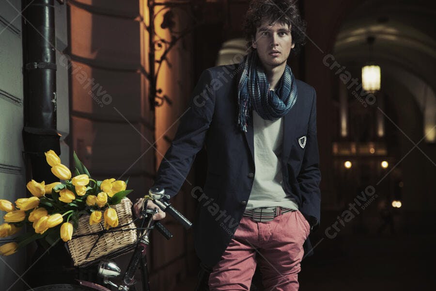 Homem com bicicleta e tulipas amarelas à noite