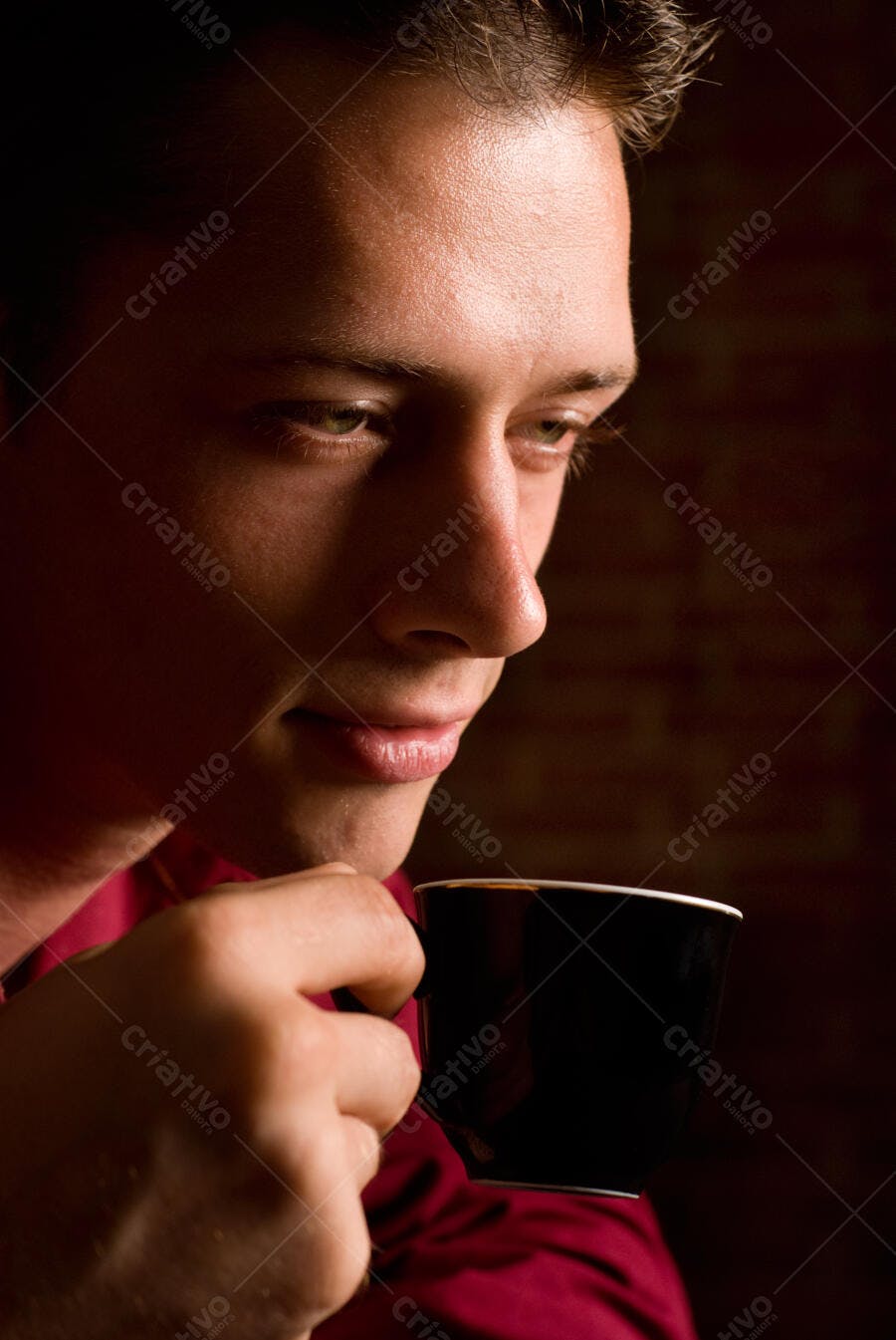 Homem apreciando café em ambiente escuro
