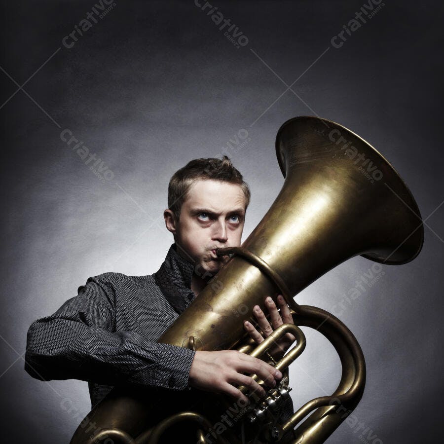 Homem tocando tuba em estúdio fundo cinza