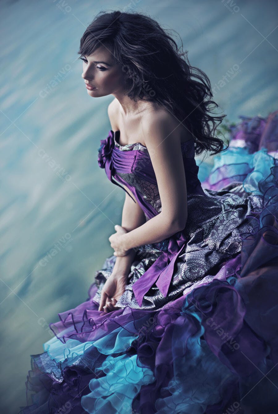 Mulher em vestido roxo e azul perto da água