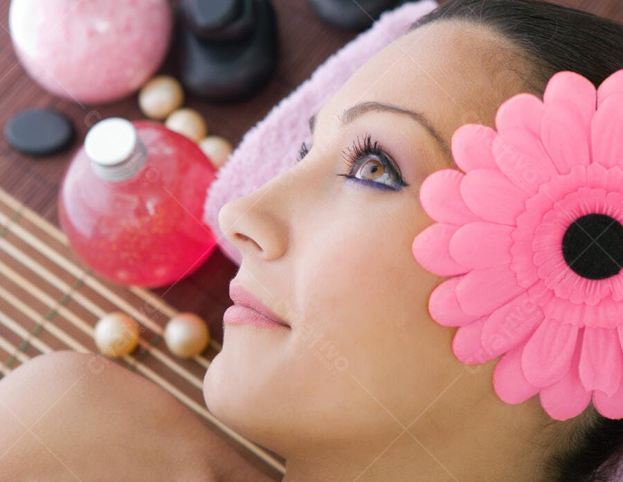 Mulher relaxada em spa com flor rosa