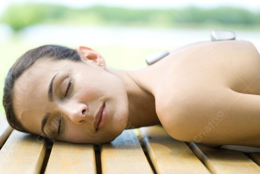 Mulher relaxada em tratamento de pedras quentes