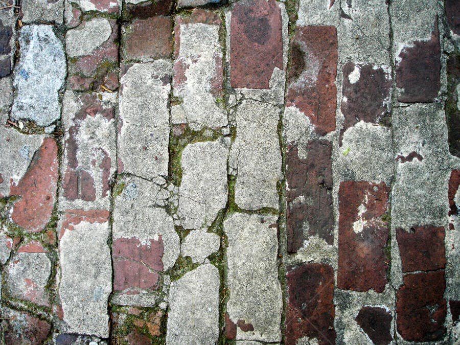 Calçamento antigo de tijolos e concreto