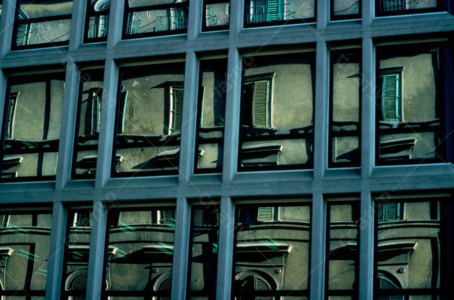 Reflexo de prédio antigo em fachada moderna