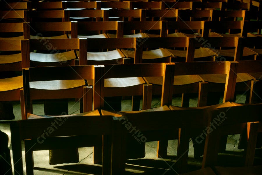 Cadeiras de madeira em igreja iluminadas