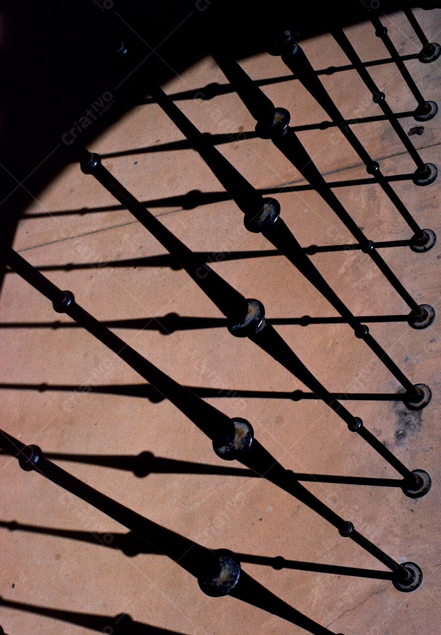 Barras de ferro e sombras longas