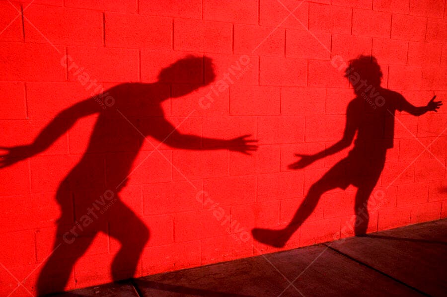 Sombras em movimento numa parede vermelha