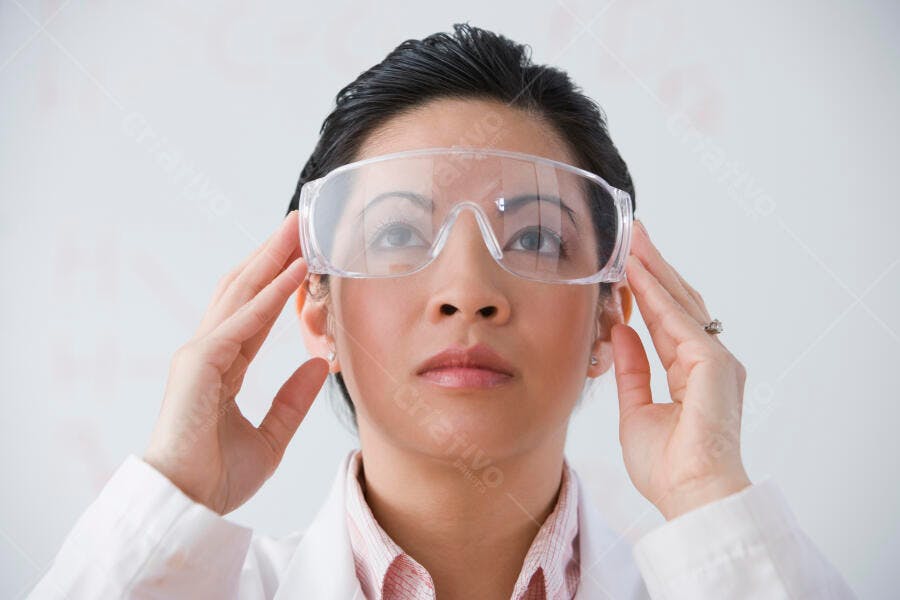 Cientista asiática ajustando óculos de proteção