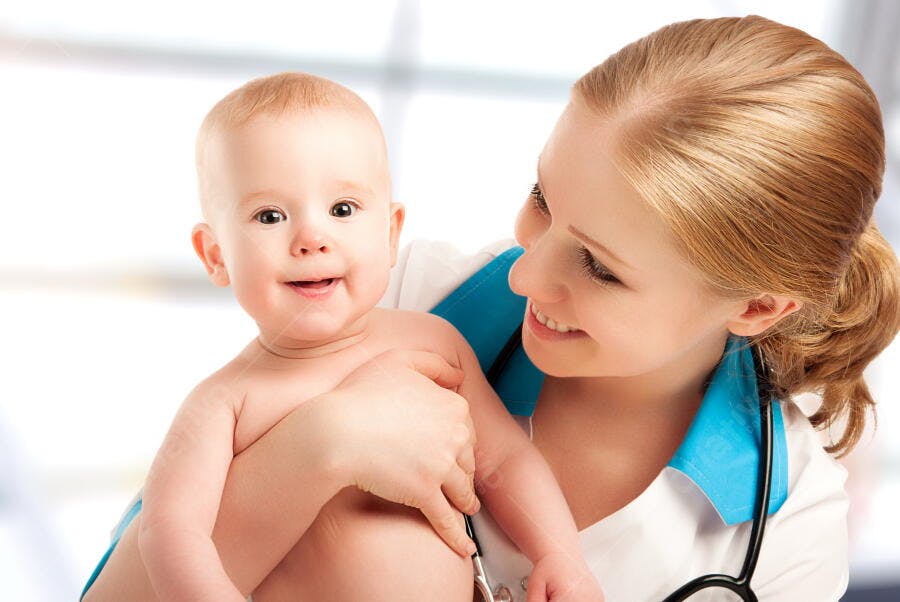 Bebê sorrindo com médica pediatra