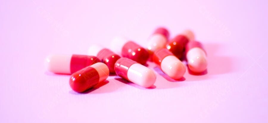 Cápsulas medicinais rosa e vermelhas
