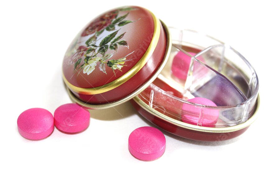 Compartimento de pílulas rosa em caixa vintage