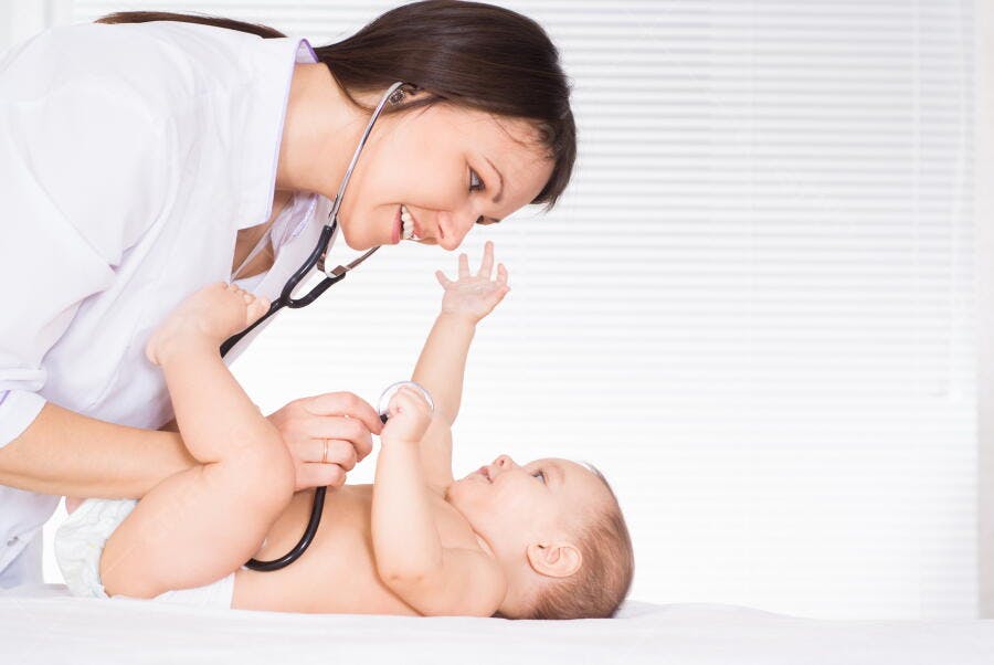Médica examinando bebê com estetoscópio