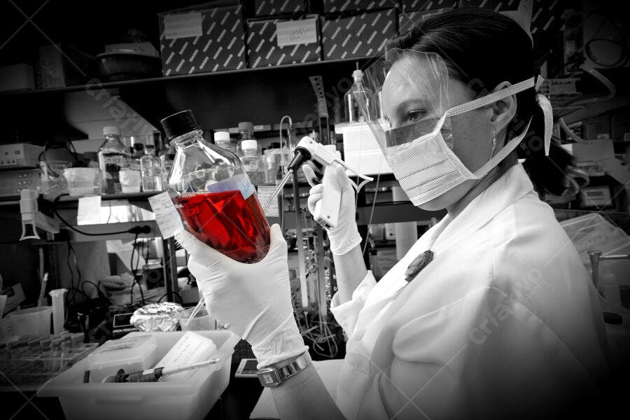 Cientista analisando amostra vermelha em laboratório