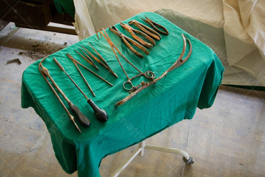 Instrumentos cirúrgicos antigos sobre mesa verde