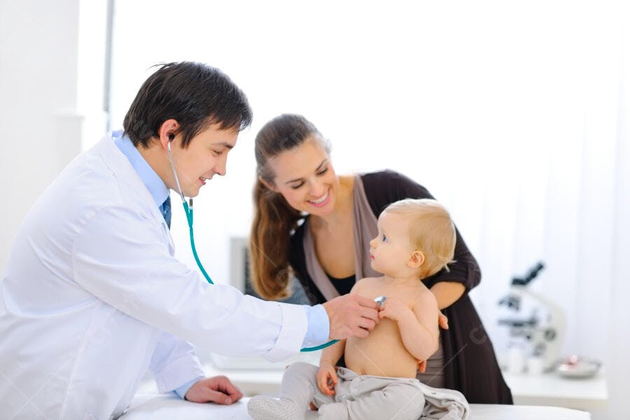 Bebê em consulta médica com mãe e pediatra