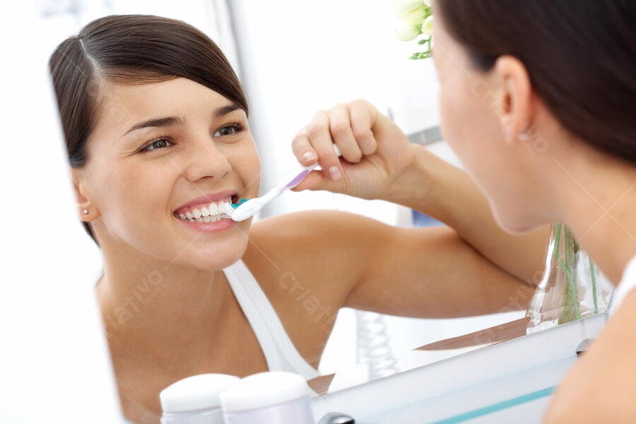 Mulher escovando os dentes no banheiro