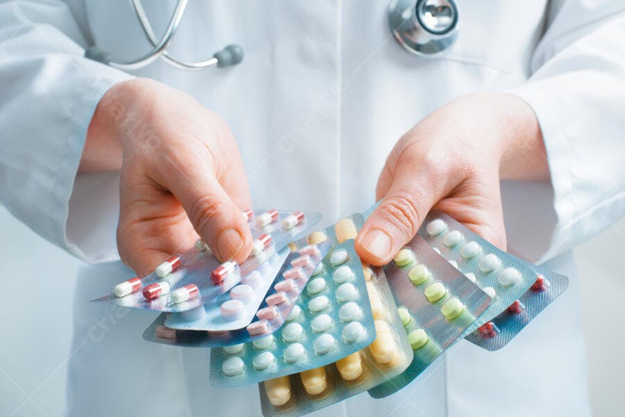 Médico segurando cartelas de remédios