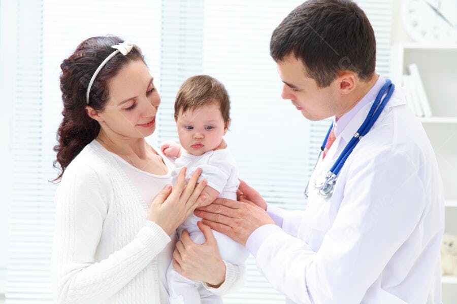Bebê em consulta médica com mãe e pediatra