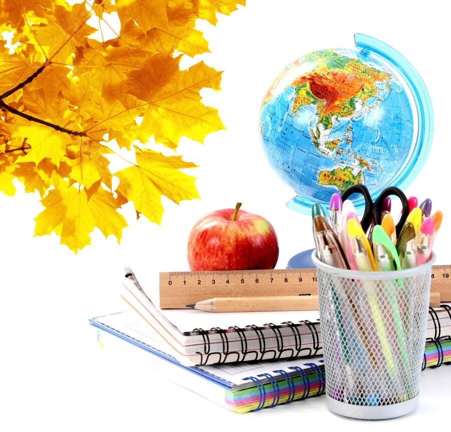 Material escolar outono com maçã e globo