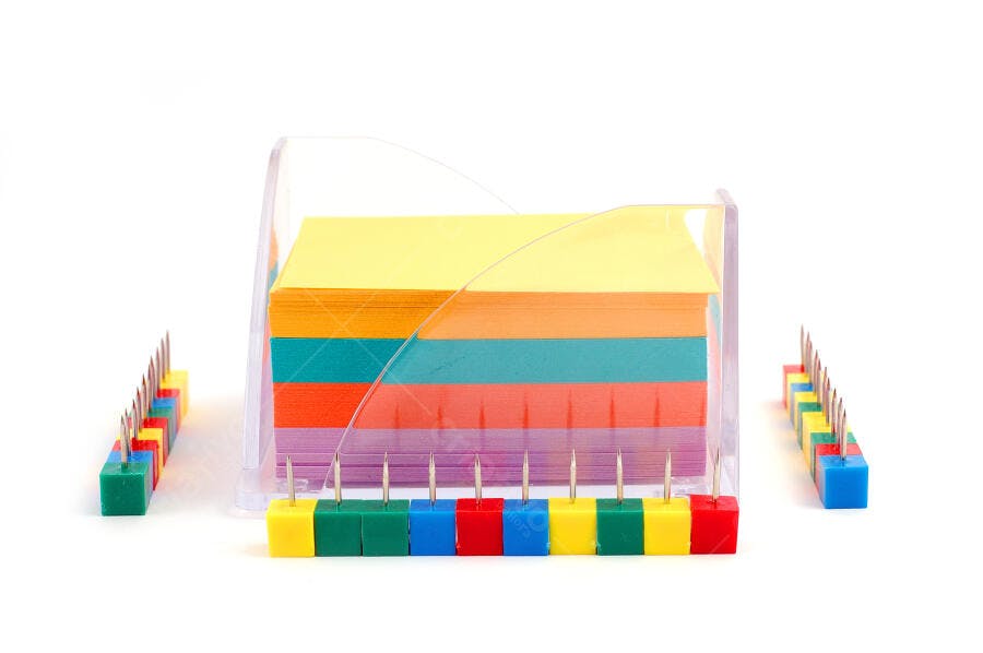 Bloco de notas coloridas com pinos coloridos