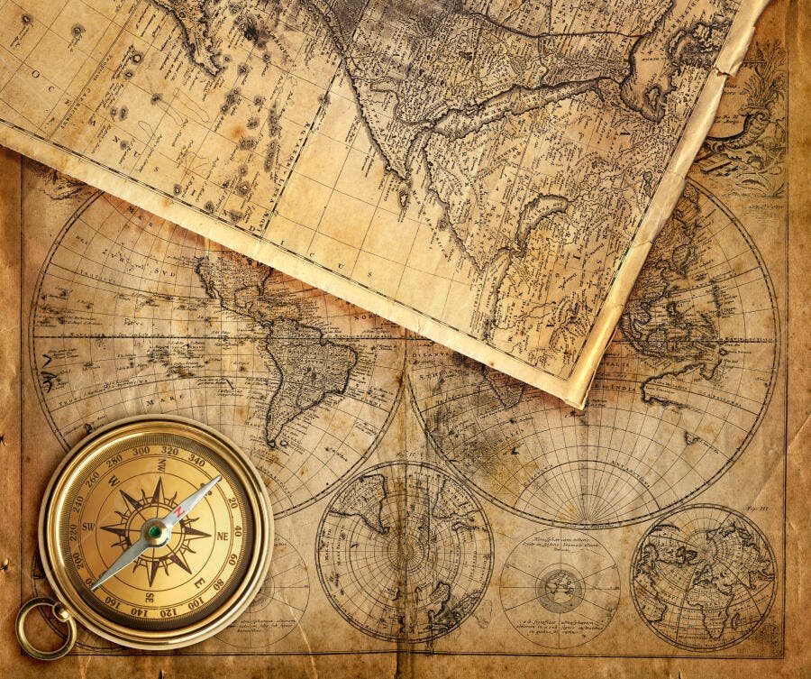 Bússola e mapas antigos sobre fundo envelhecido