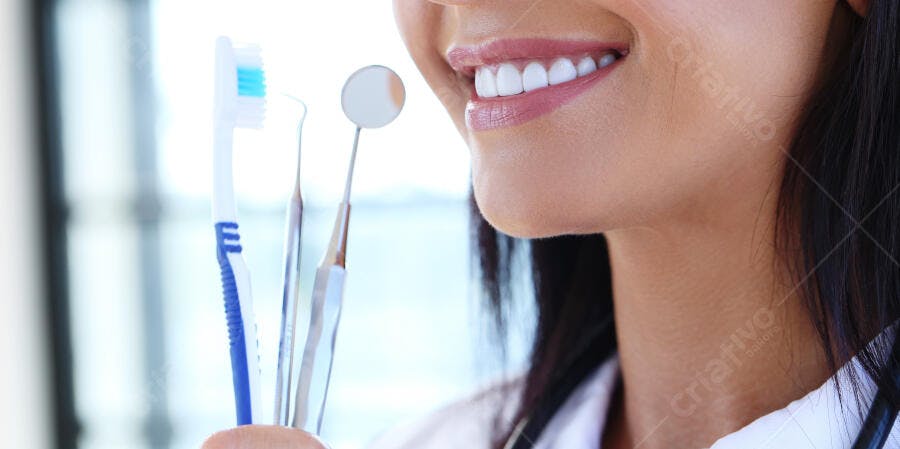 Dentista com sorriso brilhante segurando instrumentos