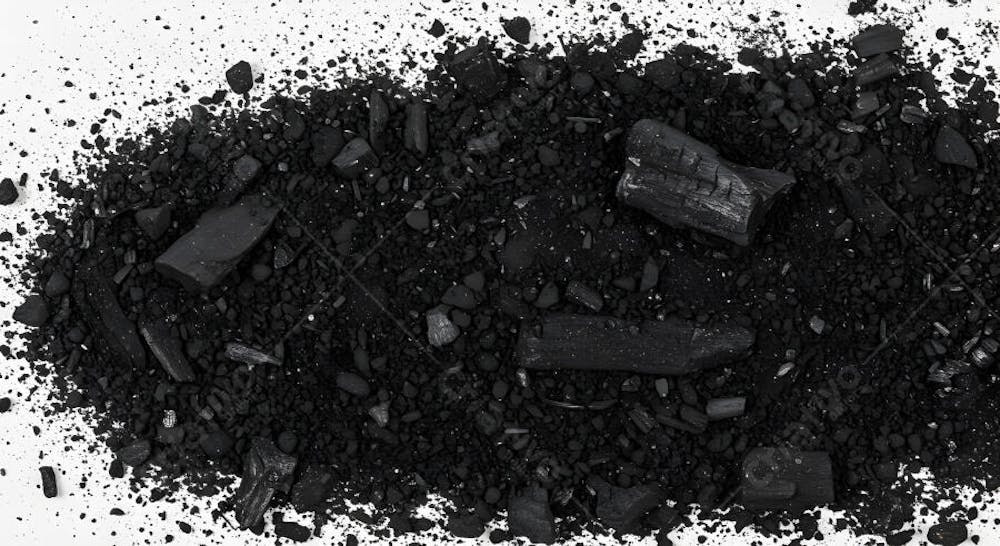 Pó de carvão preto espalhado em superfície branca