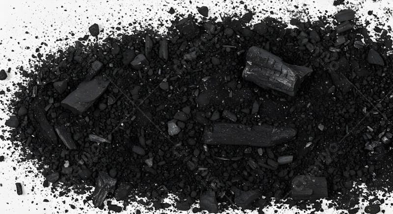 Pó de carvão preto espalhado em superfície branca